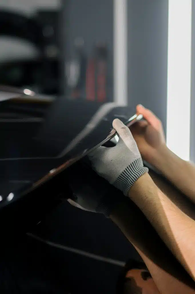 a mechanic installs a spoiler on a modern luxury car car detailing car repair garage
