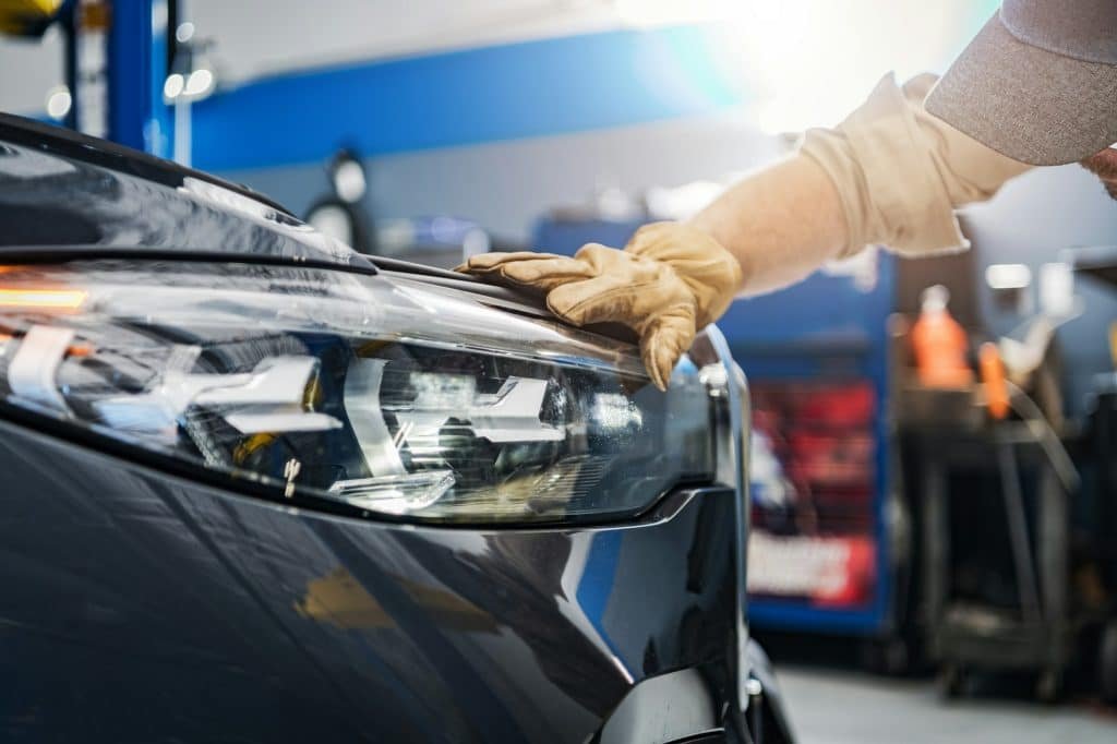 Auto Service Technician Checking on a Car Headlight