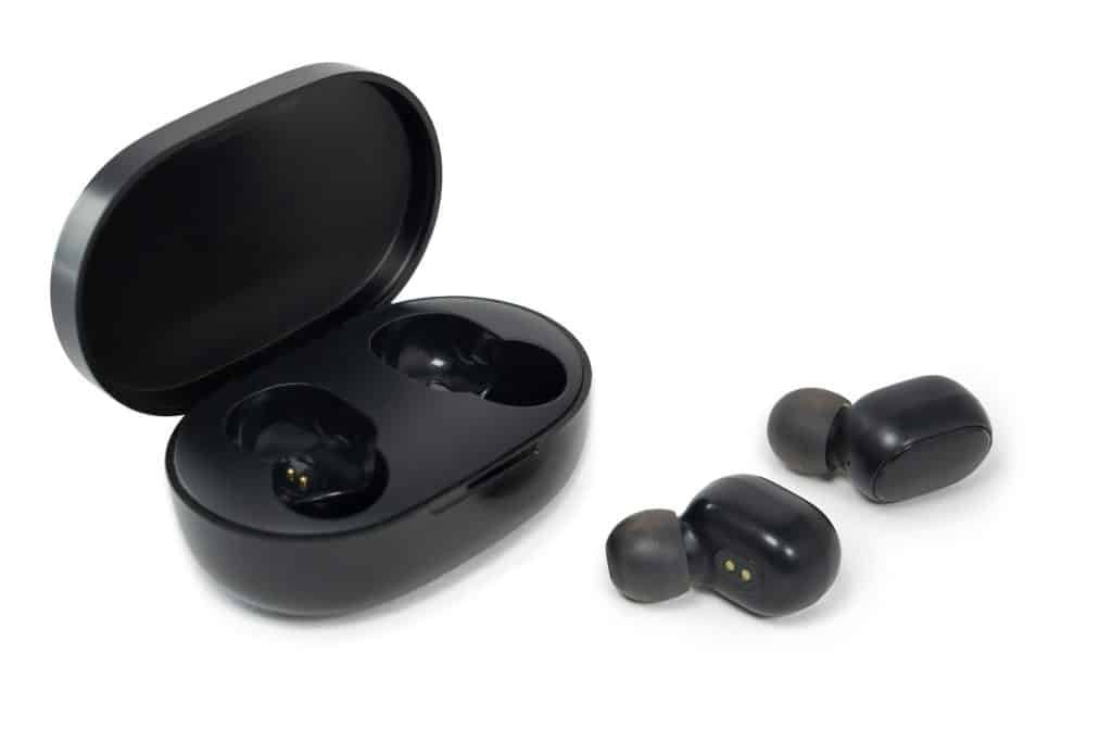 Modern wireless earbuds headphones with charging case isolated